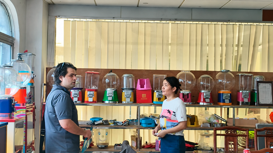 Conversaciones sobre los mecanismos y detalles de las máquinas expendedoras durante una visita de trabajo.